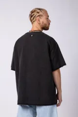 Remeron de algodón rústico con efecto de lavado gastado, corte oversize, cuello redondo y mangas cortas con terminaciones al corte.