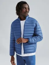 Campera puffer acolchada color azul, con cuello alto y cierre frontal.