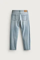 Jeans regular fit de mezclilla negra con efecto lavado, corte recto y tiro medio. Cuenta con diseño de cinco bolsillos y cierre frontal con cremallera y botón.