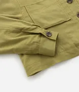 Campera corta color verde oliva, confeccionada en viscolino, con cuello inglés, abotonada adelante, bolsillos y manga larga ajustada.