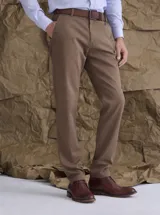 Pantalón de gabardina color marrón, de corte recto, con bolsillos laterales y traseros. Presenta cierre de botón y cremallera, y trabillas para cinturón.