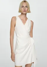 Vestido corto de tejido fluido en color blanco, con escote cruzado, diseño sin mangas y cierre lateral con lazo.
