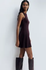 Vestido corto sin mangas en punto roma, de color bordó, con cuerpo entallado, escote redondo y falda con vuelo.