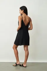 Vestido corto negro de tirantes finos con escote redondo, de corte suelto y fluido.