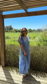 Vestido largo de lino color azul marino, con escote en V y mangas cortas amplias. Presenta un corte relajado y bolsillos laterales.