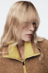 Chaqueta de punto de textura bouclé en color marrón, con cuello subido, manga larga y cierre frontal con cremallera. Presenta detalles de ribetes y acabados en color verde lima a contraste en cuello, cierre, bolsillos y puños.