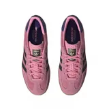 Championes adidas Gazelle Indoor de gamuza en color rosado con las icónicas tres tiras laterales en negro. Presenta un diseño clásico de perfil bajo con suela de goma translúcida y detalle en el talón en color azul oscuro.