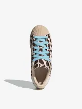 Championes Adidas Superstar II con diseño de estampado animal print tipo vaca, puntera de goma clásica, tres tiras laterales blancas y cordones en color celeste.