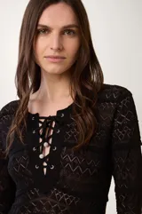 Vestido largo de punto calado color negro, con mangas largas y escote en pico con cierre de lazada.