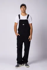 Jardinero de denim negro con corte relajado, breteles regulables con hebillas metálicas, bolsillo frontal tipo parche y bolsillos laterales.