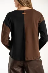 Sweater de algodón con diseño bicolor en bloques, combinando tonos marrón y negro. Presenta cuello redondo, mangas largas y una textura acanalada.
