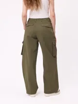 Pantalon cargo de corte recto y tiro medio, con estampado de camuflaje tipo bosque en tonos beige y marrones. Cuenta con bolsillos laterales tipo cargo con solapa y cierre de botón.