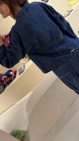 Camisa de denim azul con cuello mao, diseño holgado, mangas largas y cierre frontal con botones metálicos. Cuenta con costuras decorativas pespunteadas en el delantero.