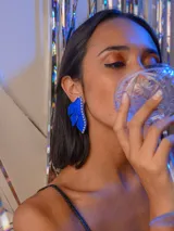 Aros colgantes con forma de media flor color azul y detalle de strass.