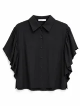 Camisa negra de manga corta con volados amplios en las mangas, cuello camisero clásico y cierre frontal de botones.