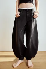 Jeans de tiro medio y diseño balloon, color azul denim con efecto lavado, cinco bolsillos, cierre frontal con cremallera y botón metálico, y bajos acabados en puño.