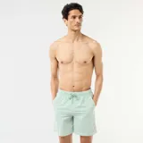 Short de baño con diseño de rayas finas en color verde claro y blanco, con cintura elástica y cordón ajustable.