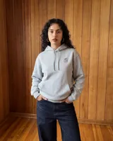 Canguro gris con capucha y cordones ajustables, bolsillo frontal tipo canguro, puños y cintura acanalados. Presenta un pequeño logo estampado en el pecho y detalle de marca en la manga.