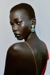 Pendientes colgantes con diseño de doble piedra engarzada en metal dorado y plateado, rodeadas por una hilera de cristales brillantes. La piedra superior es de color verde claro y la inferior es de color azul.