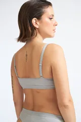 Sostén gris con encaje en el escote, de breteles finos y espalda lisa.