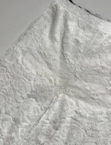 Pantalón ancho de encaje blanco con diseño floral, tiro alto y elástico en la cintura.