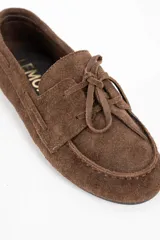 Mocasin de gamuza color marrón con detalle de flecos en el empeine y costuras reforzadas.