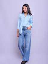 Camisa de manga larga a rayas verticales celestes y blancas, de corte suelto, confeccionada en algodón.