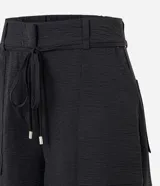 Short de corte recto y cintura alta, confeccionado en tejido airflow con textura arrugada. Presenta trabillas, lazo ajustable en la cintura, cierre tradicional y bolsillos laterales tipo carpintero.