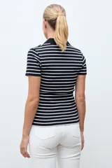 Remera de tejido canalé a rayas horizontales blancas y negras, con cuello polo y escote en V sin botones, de manga corta y corte ajustado.