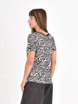 Remera de manga corta con cuello redondo, confeccionada con un estampado animal print de leopardo en tonos negros y beige.