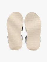 Sandalias de plataforma con suela gruesa dentada color crema. Presentan tiras de tejido trenzado en tonos beige y celeste claro, con cierre adherente y parche tonal de marca en la tira.