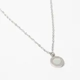 Colgante de cadena fina de acero con dije circular que presenta números romanos en el borde y un centro nacarado.