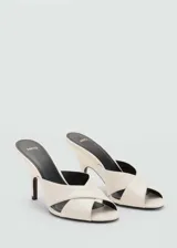 Sandalia tipo mule de cuero ovino, color crema, con diseño de tiras cruzadas en el empeine, puntera abierta y tacón tipo embudo.