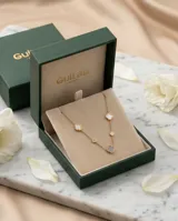 Collar de acero con baño de oro, compuesto por una cadena fina con dijes en forma de flor distribuidos a lo largo de la misma, con incrustaciones de nácar y circonia.
