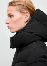 Campera puffer larga de color negro, con diseño acolchado de líneas diagonales, capucha ajustable y cierre frontal con cremallera.