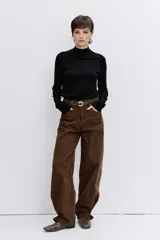 Jersey de punto fino en color negro, con cuello alto y mangas largas ajustadas.