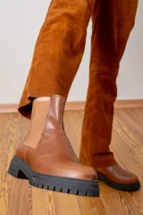 Bota tipo Chelsea de cuero color chocolate, con paneles laterales elásticos en tono contrastante y suela track de goma negra.