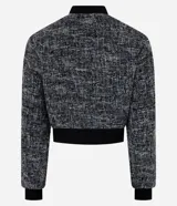 Campera bomber corta confeccionada en tweed con cuello alto, cierre frontal con cremallera, bolsillos y detalles en rib.