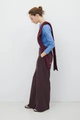 Pantalon de corte sastrero y pierna ancha, confeccionado en tela melange. Presenta cintura con trabillas, cierre frontal con botón y bolsillos laterales.
