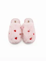 Pantuflas de peluche color blanco con estampado de corazones rojos, diseño abierto y suela plana.