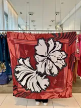 Pañuelo cuadrado grande color rojo con estampado de flores blancas y negras.