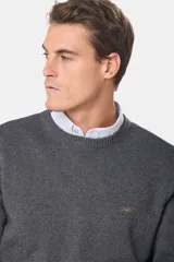 Buzo tejido de lana con escote redondo a la base y mangas largas. Presenta puños y ruedo acanalados, con un pequeño logo bordado en el pecho.