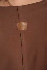 Remera de algodón color rosado con mangas cortas abullonadas de broderie con diseño floral calado. Presenta cuello redondo y costura vertical central en el frente.