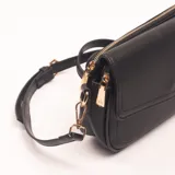 Bandolera negra con correa de mano y correa larga desmontable, cierre superior con cremallera dorada y solapa con broche imantado.