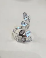 Anillo de acero quirúrgico de diseño abierto con forma de ramas con hojas pavimentadas con circonitas.