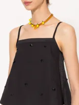 Top de poplin negro con breteles finos, escote recto y detalle de piedras decorativas al tono distribuidas en el frente y la espalda. Presenta terminaciones en satén en escote y aberturas laterales, con cierre invisible lateral.