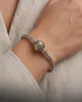 Pulsera de plata 925 y lámina de oro 18k de la línea Hindi, con diseño trenzado y una esfera central decorada con detalles tallados.