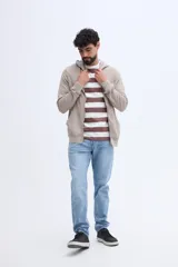 Campera canguro de algodón color beige con capucha, cierre frontal y bolsillos laterales, confeccionada con felpa diferenciada.