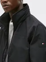 Campera negra de Tommy Hilfiger, modelo Regatta, con cuello alto, cierre de cremallera, dos bolsillos laterales y logo engomado bordado en la manga.