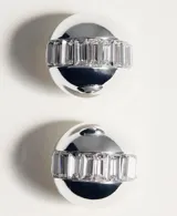 Aros de clip plateados con diseño abombado y detalles texturizados de cristales incrustados en el centro.